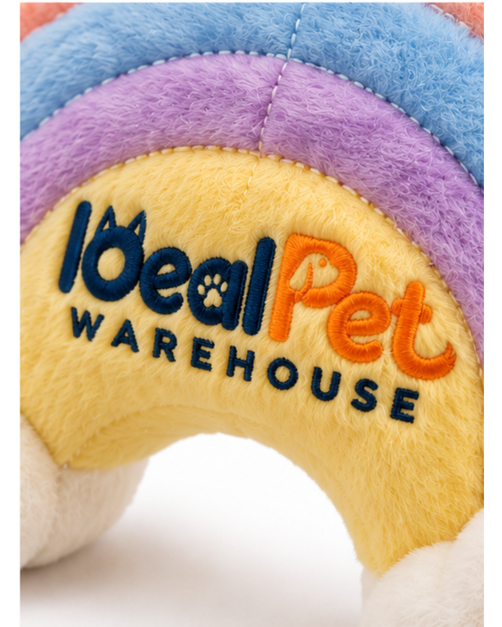 Close-up of the embroidered logo on the yellow center band of the rainbow plush
