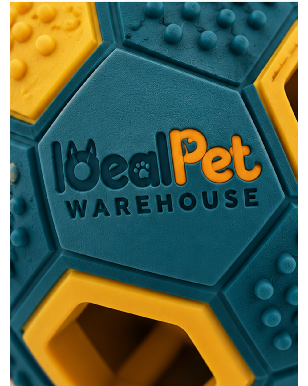 Close-up of the recessed logo and a hexagonal opening on the teal rubber treat toy